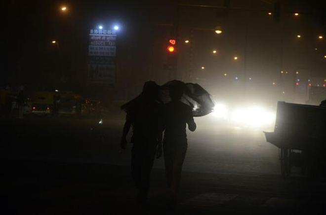 Delhiites wade through dust left in the wake of a high-velocity dust storm that hit the capital on the evening of Monday, May 7, 2018