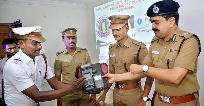 Commissioner of Police A. Amalraj handing over a swiping machine to a traffic police officer in Tiruchi on Monday.