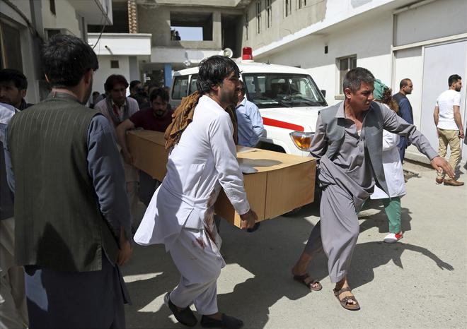 Relatives carry the coffin of a victim after a deadly suicide attack, in Kabul, Afghanistan, Monday, June 11, 2018. Afghan officials said a suicide bomber on foot struck the Rural Rehabilitation and Development Ministry as employees were leaving work in the capital.
