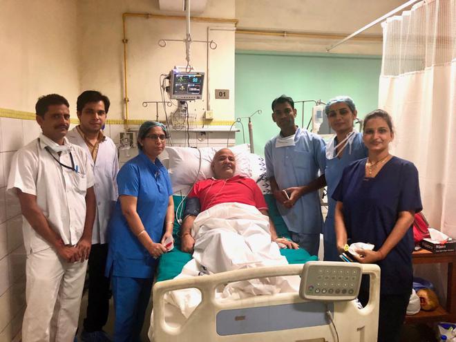 Delhi's Deputy Chief Minister Manish Sisodia, with staff at LNJP Hospital on Tuesday.