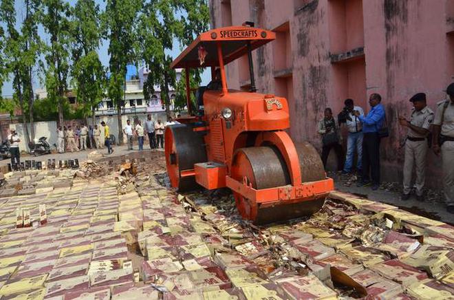 Pounded: A file photo of seized liquor bottles being destroyed near Patna.