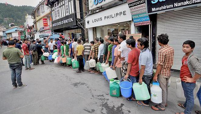 People stand in a queue to collect drinking water at Shimlaâs Mall Road on Sunday.