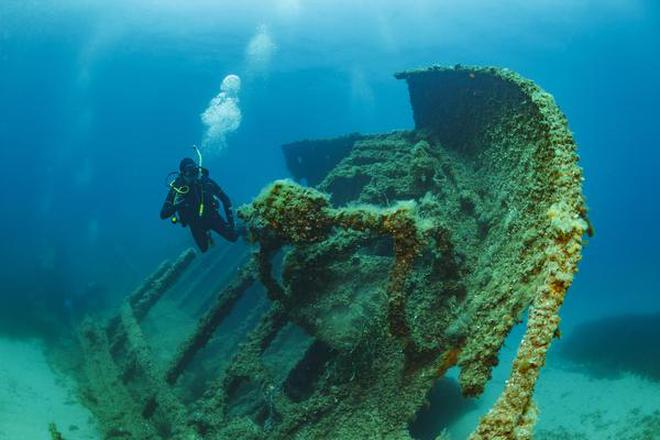 A scuba diver explores a shipwreck.
