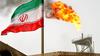 A gas flare on an oil production platform in the Soroush oil fields is seen alongside an Iranian flag in the Persian Gulf, Iran, July 25, 2005. Photo