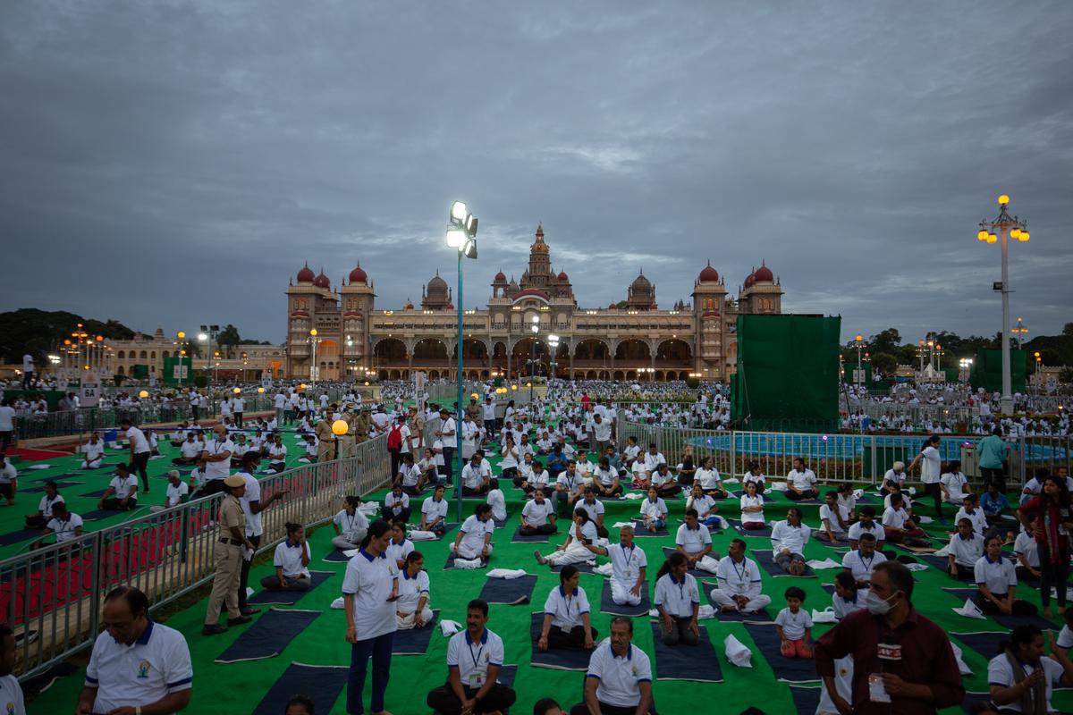 People prepare to perform yoga in front of the Mysore Palace during the International Day of Yoga celebrations, on June 21, 2022, in Mysuru, India. 