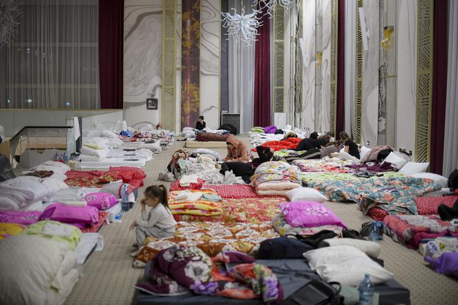 Refugees who fled the conflict from neighboring Ukraine sit in the event hall of a hotel offering shelter in Siret, Romania on February 26, 2022. 