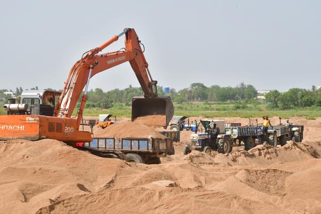 Mechanised work: An excavator fills tractors with sand at a site permitted by the government.
