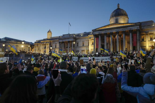 Demonstrators hold placards and Ukraine flags during a protest in Trafalgar Square in London on February 27, 2022.