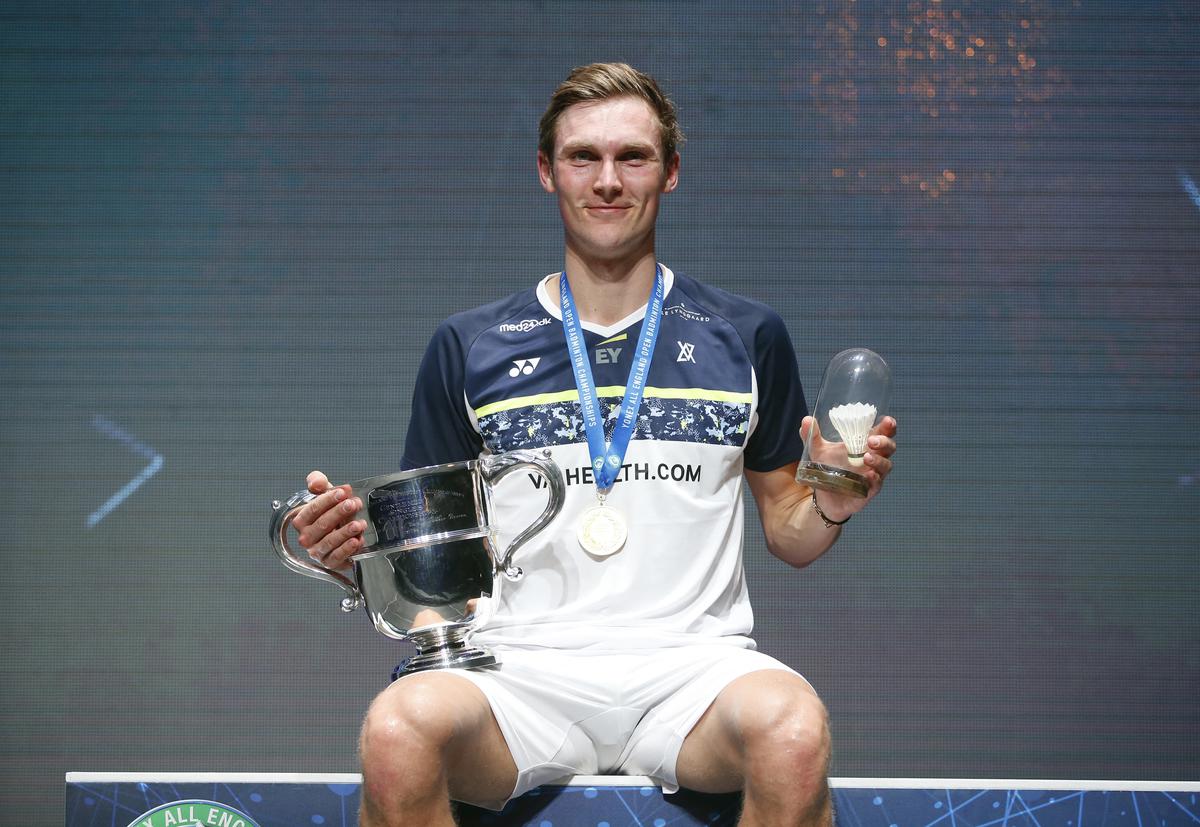 Viktor Axelsen of Denmark celebrates on the podium with the trophy after winning the men's singles final of the All England Open 2022 at the Utilita Arena in Birmingham, Britain March 20, 2022.