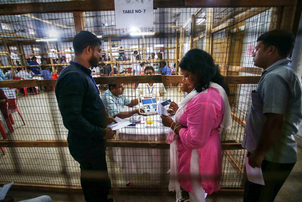 Election staff members with an Electronic Voting Machine (EVM) during the counting of votes of the Tripura Assembly by-elections, at a counting centre in Agartala on June 26, 2022. 