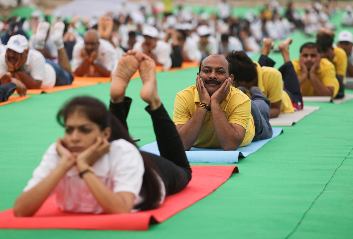 People perform yoga on the banks of the river Yamuna, during International Yoga Day in New Delhi, India, on June 21, 2022.