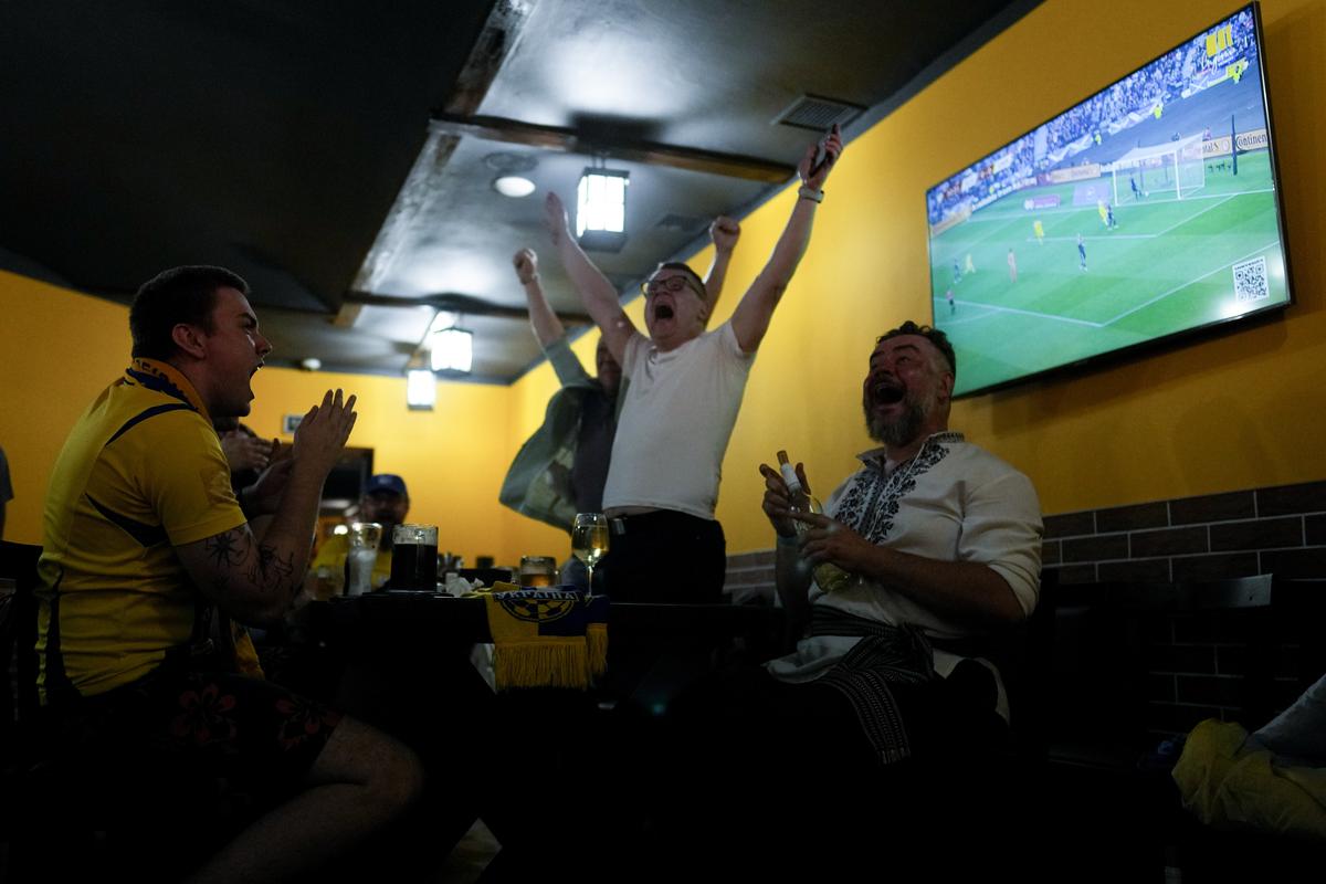 Ukrainian fans at a bar in Kyiv celebrate after Ukraine’s Andriy Yarmolenko scored the opening goal in the World Cup 2022 qualifying play-off match against Scotland