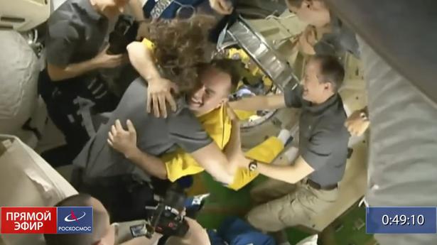 3 Russian cosmonauts arrive at space station in yellow and blue