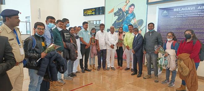 Rajya Sabha MP Eeranna Kadadi, Deputy Commissioner M.G. Hiremath and Airport Director Rajkumar Mourya welcoming students who reached Sambra in Belagavi from Ukraine on Monday.  