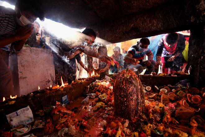 Devotees perform puja at one of the 101 Shivalingas at Sri Ramalingeswara Swamy Temple in Keesaragutta on the outskirts of Hyderabad on Tuesday. 