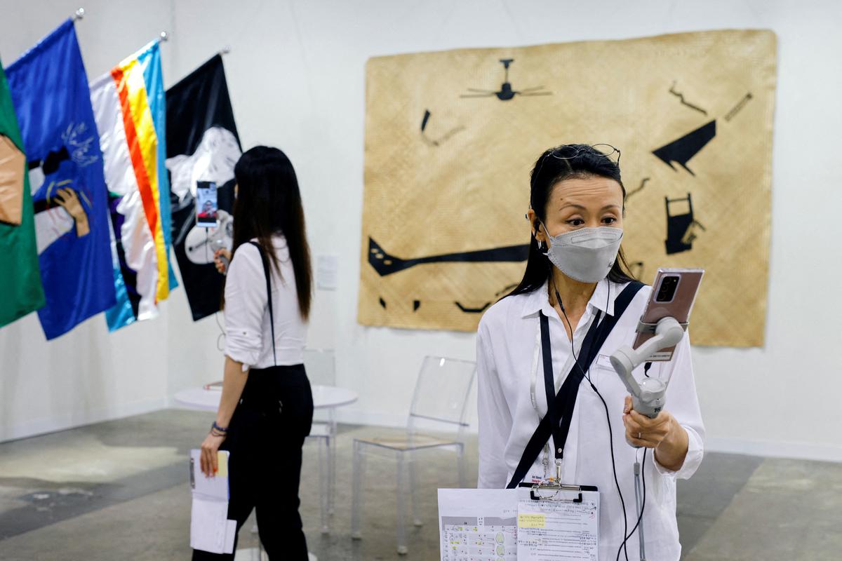 Staff talk to overseas visitors by phone at Art Basel in Hong Kong