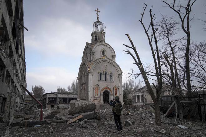 A Ukrainian serviceman takes a photograph of a damaged church after shelling in a residential district in Mariupol, Ukraine, on March 10, 2022.
