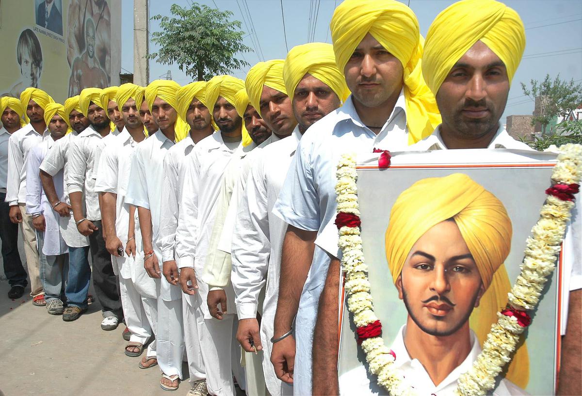 File photo of members of Punjab Shaheed Bhagat Singh Youth Sports and Welfare Club with a potrait of freedom fighter Bhagat Singh.  While Singh wearing yellow turban is famous, historians claim it is an artistic impression and not his original image.