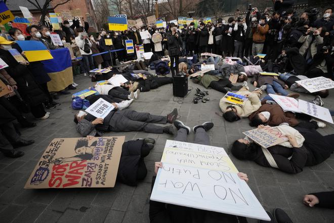 Protesters lie down on the ground during a rally against Russia’s invasion of Ukraine, near the Russian Embassy in Seoul, South Korea, on February 28, 2022. 