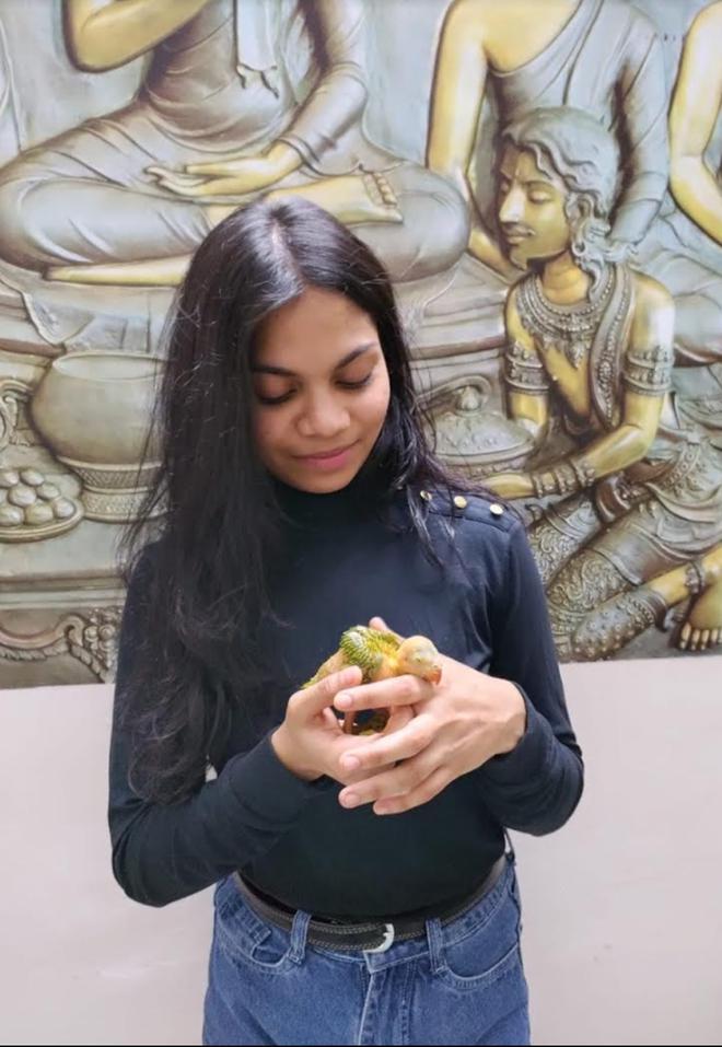 Vemula Keerthi with a parrot chick.