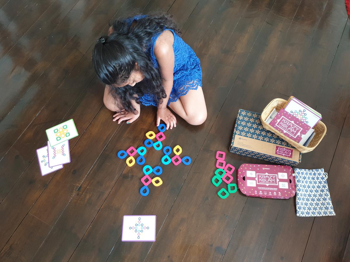 A child playing with Studio Maniam’s Krazy Kolam game. 