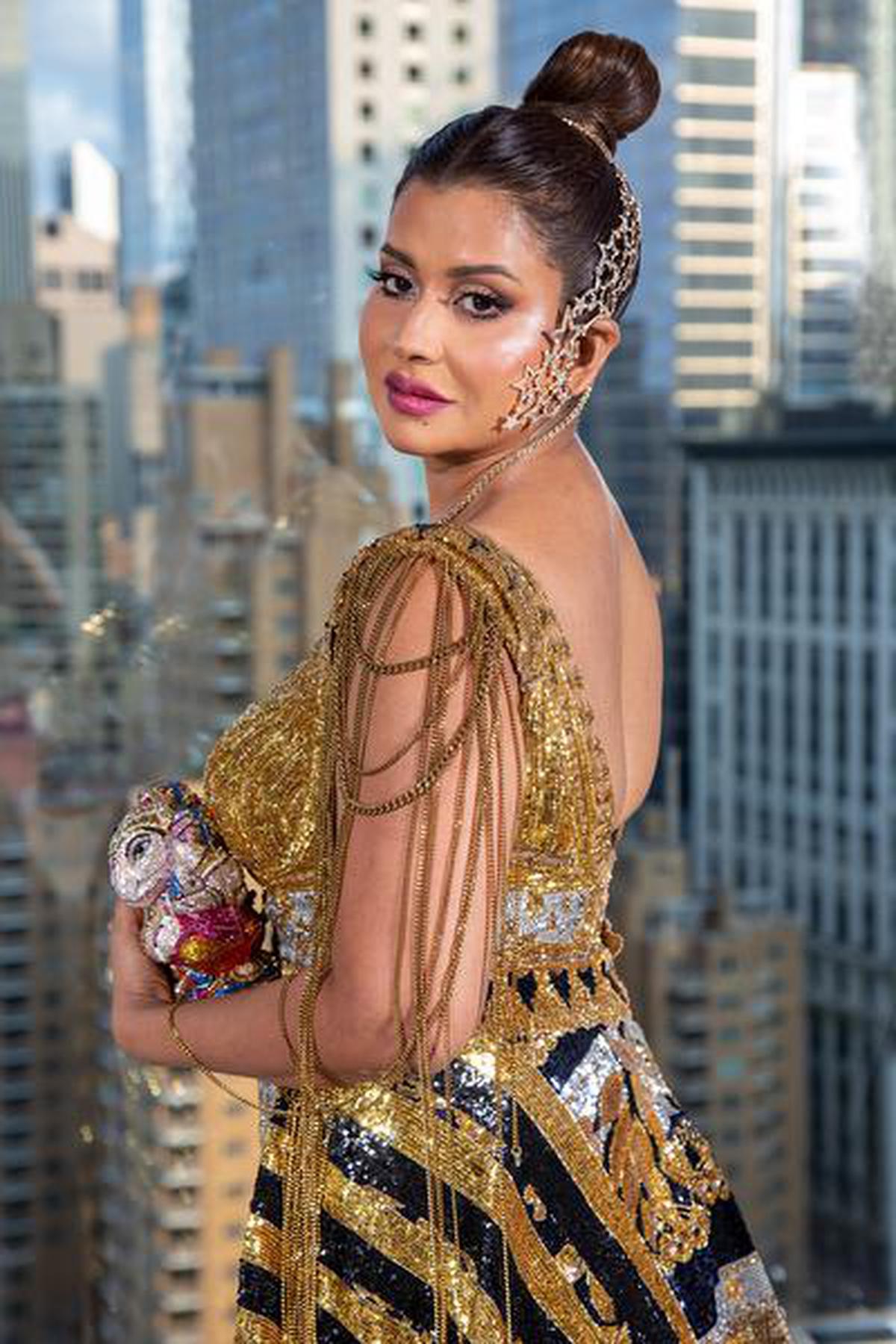 Sudha Reddy in her 2021 Met Gala custom gown by Falguni and Shane Peacock, a diamond-encrusted earcuff by Farah Ali Khan, Chanel sequined gold stilettos and the Ganesha clutch by Judith Leiber