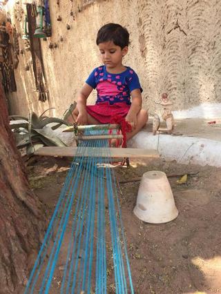 A child learning the craft of weaving