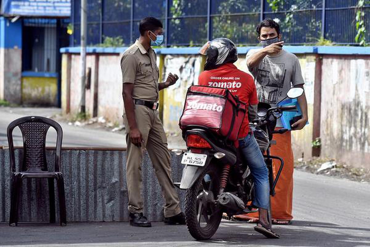 On guard: A police officer checking a motorist in the containment zone at Elamakkara in Kochi on Saturday.