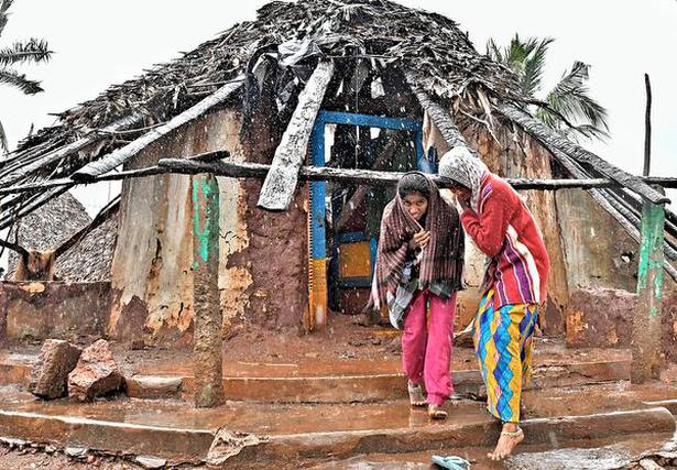 Two girls coming out of their damaged hut at Mangamaripeta.