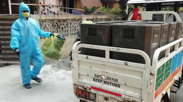 Conservancy workers start collecting waste in yellow bags from houses with active cases