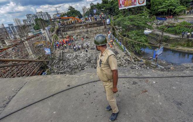 A policeman stands guard as rescue and relief works are carried out at the site of Majerhat bridge collapse in Kolkata on September 5, 2018.