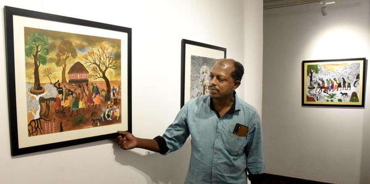 Artist Ramesh M.R. with his paintings exhibited at the Kerala Lalithakala Akademi Art Gallery in Kozhikode.