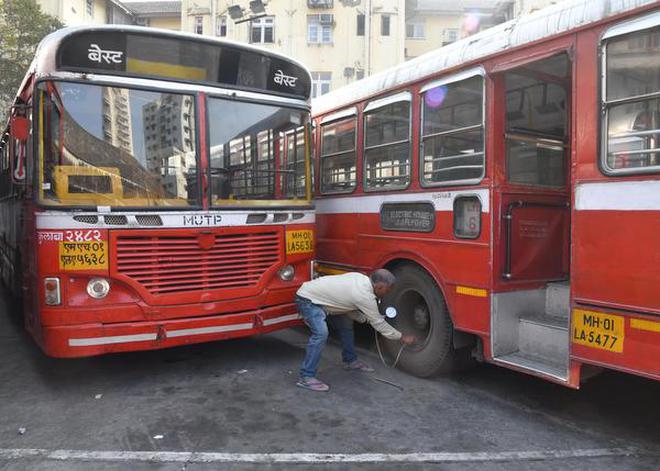 A BEST worker checks tyre pressure of a bus before it goes back on the road.