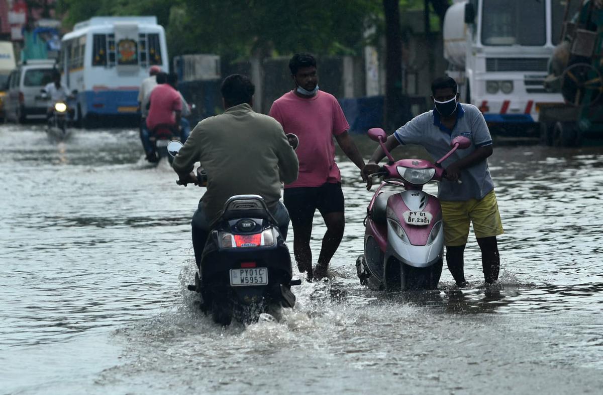 Commuters wading through water-logged streets in Puducherry on Thursday.