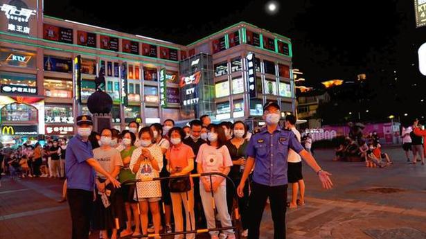 Chinese city locks down an area amid virus surge