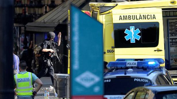 An armed policeman arrives in a cordoned off area after a van ploughed into the crowd, injuring several persons on the Rambla in Barcelona on Wednesday. 