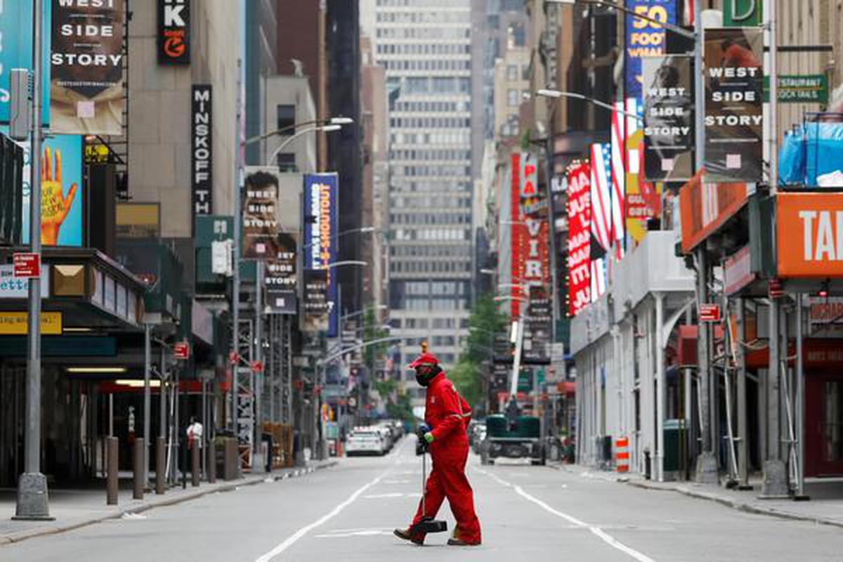 A street cleaner walks through the closed Broadway theatre district near Times Square.