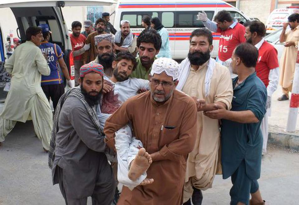 An injured Pakistani man is brought to a hospital in Quetta on Friday following a bomb blast at an election rally.
