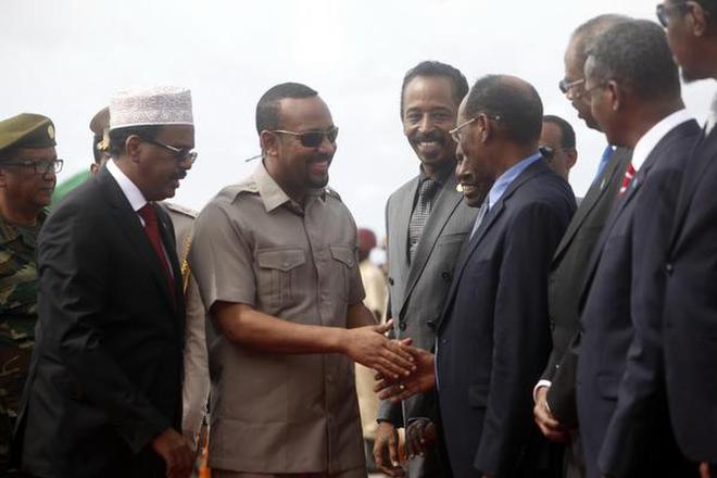 In this June 16, 2018 file photo, Somali President Mohamed Abdullahi Mohamed, left, introduces new Prime Minister of Ethiopia Abiy Ahmed, center, to his ministers in Mogadishu, Somalia.