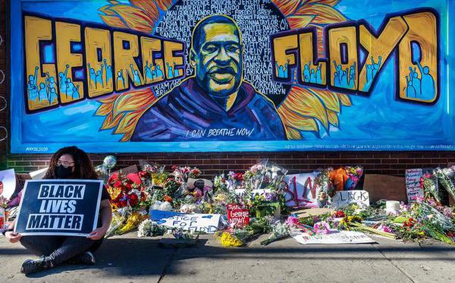 Anger on the streets: Flowers, signs and balloons are left on Friday near a makeshift memorial to George Floyd near the spot where he died while in custody of police in Minneapolis, Minnesota.