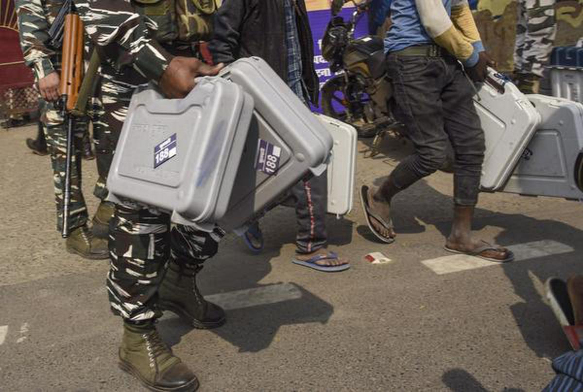 Security personnel carry Electronic Voting Machines (EVMs) as they leave for their election duty, on the eve of second phase of Bihar assembly polls, in Patna, Monday, Nov. 2, 2020.