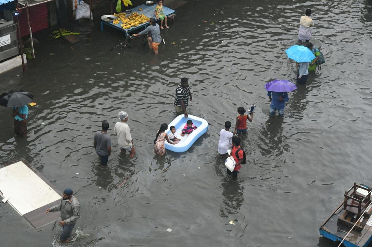 As the northeast typhoon continues to bring heavy rainfall to Chennai, with flooding in several areas, families are abandoning their homes to safer havens.  The family appears to be using a bathtub to take their children to a safe place on November 8, 2021.