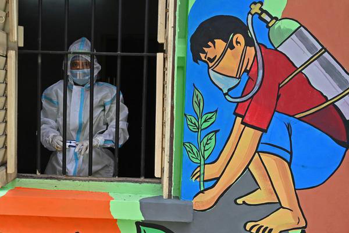 A health worker wearing a protective suit stands on the window of a newly inaugurated 'Oxygen Hub' for Covid-19 coronavirus patients in Kolkata.