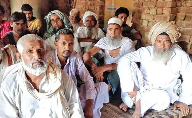 In shock: Relatives and villagers outside the house of Rakbar at Kolgaon in Haryana’s Nuh district on Sunday.