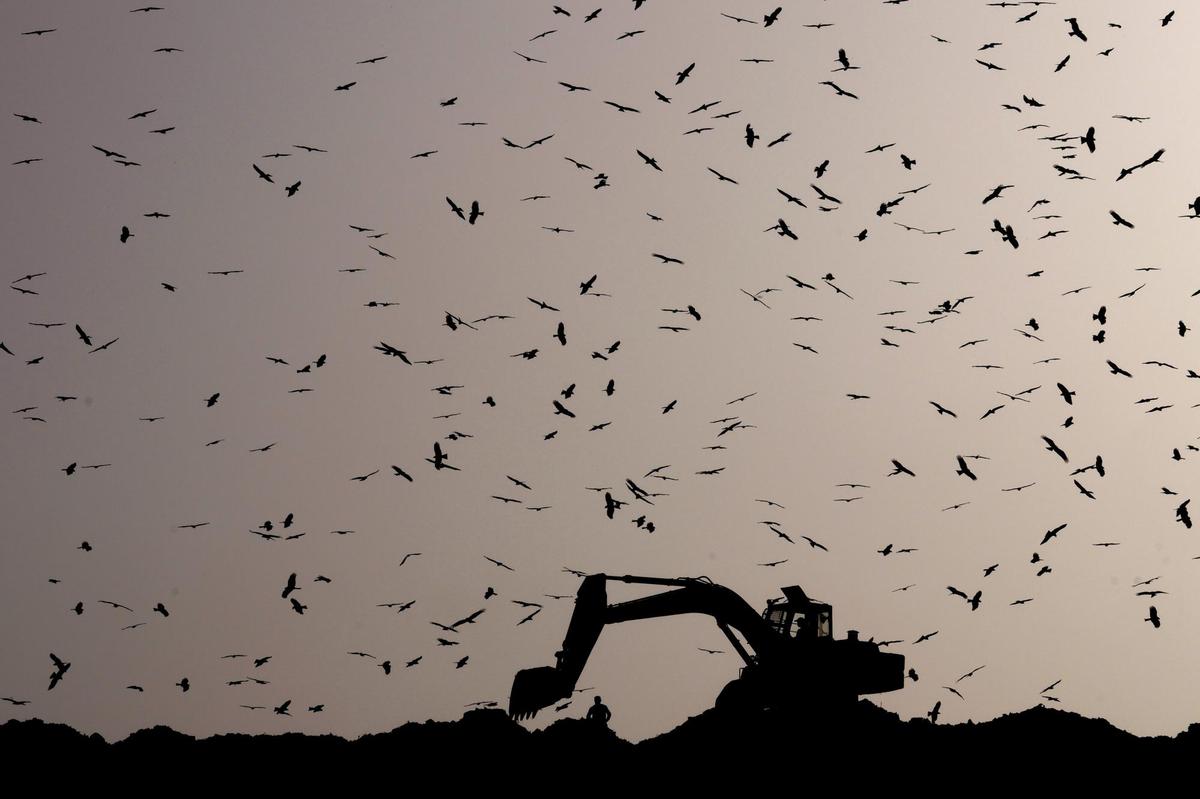 An earthmover sorts garbage at the Ghazipur garbage dump in New Delhi, March 2022.