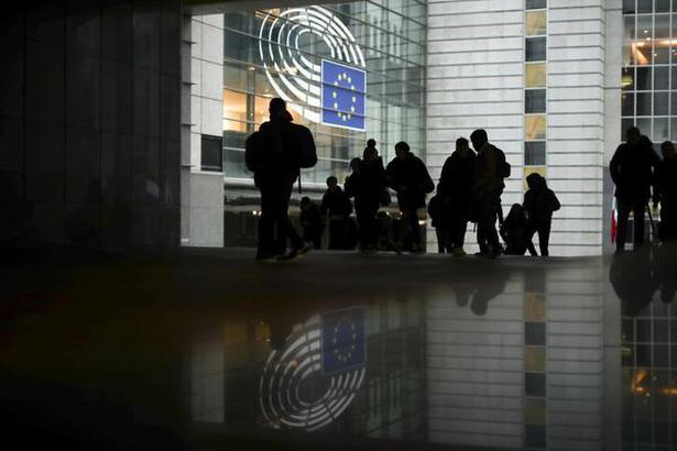 People walk past outside the European Parliament in Brussels on January 24, 2020.