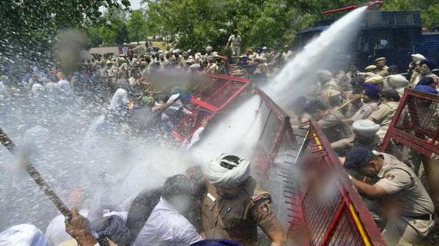 Police use water cannons to disperse protesting farmers in ...