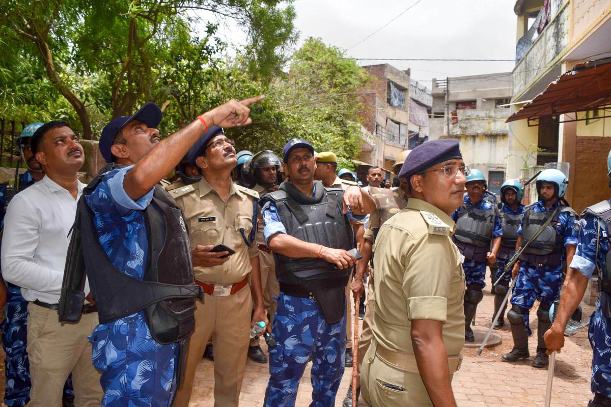 Police personnel look for illegal structures at Atala area in Prayagraj on June 11, 2022. 