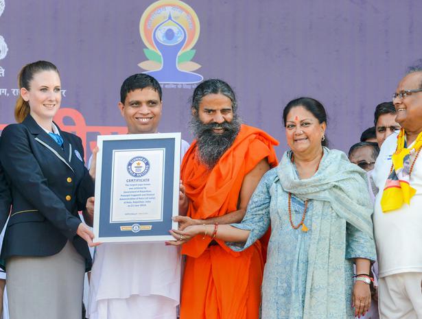 Yoga guru Baba Ramdev and Rajasthan Chief Minister Vasundhara Raje receive the Guinness World Record certificate for the lalrgest yoga session on the International Day of Yoga at Kota in Rajasthan on June 21, 2018.