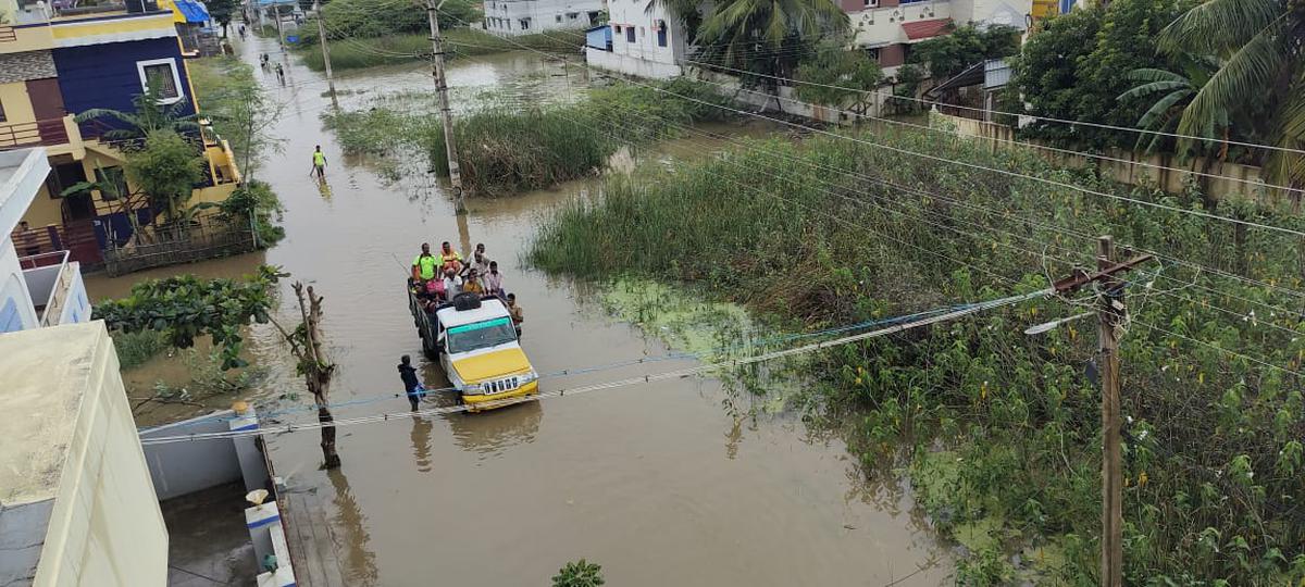 Fire and rescue personnel rescue residents of Rajalakshmi Nagar, Kuzhumani Road as their homes become inundated due to incessant rains in Tiruchi on Monday